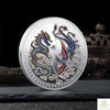 A silver commemorative coin featuring a Chinese dragon and phoenix design.