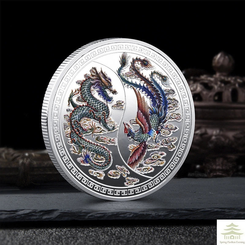 A silver commemorative coin featuring a Chinese dragon and phoenix design.