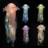 A collection of glowing jellyfish lanterns in various shades of pink, blue, and green suspended against a dark background.