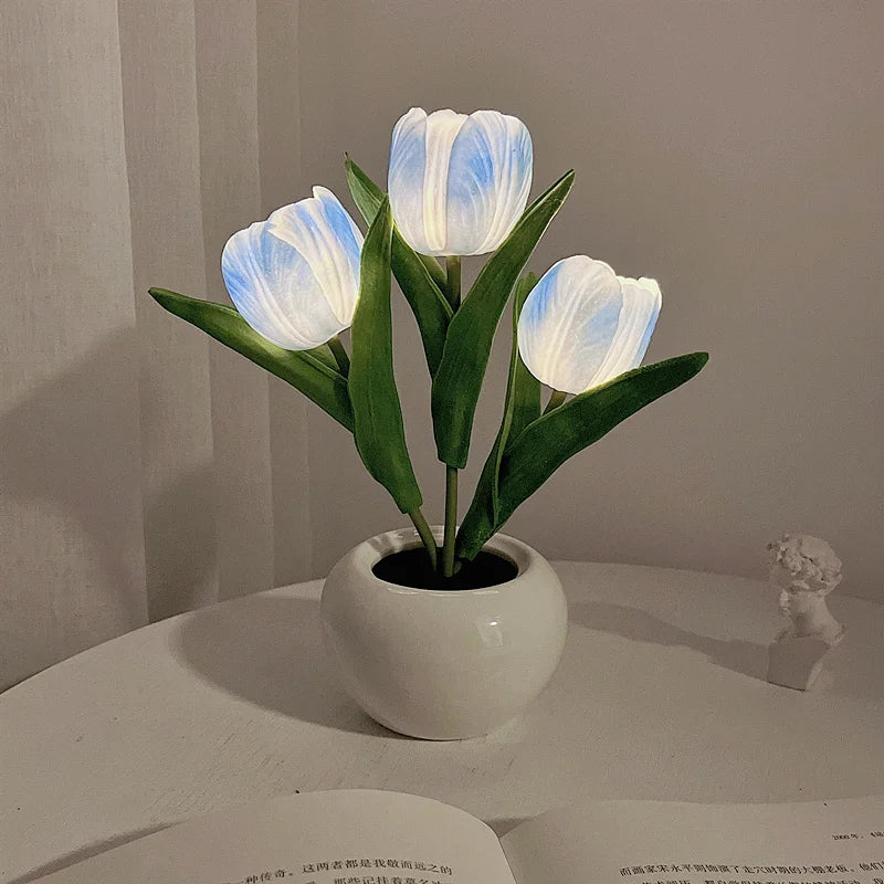 A bouquet of light blue tulips in a white ceramic pot, used as an LED night light.