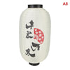 A white paper hanging lantern with black accents featuring silhouettes of birds and a red fan.
