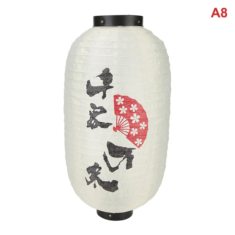 A white paper hanging lantern with black accents featuring silhouettes of birds and a red fan.