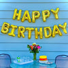 Gold foil letter balloons spelling HAPPY BIRTHDAY strung across a light blue wooden fence backdrop
