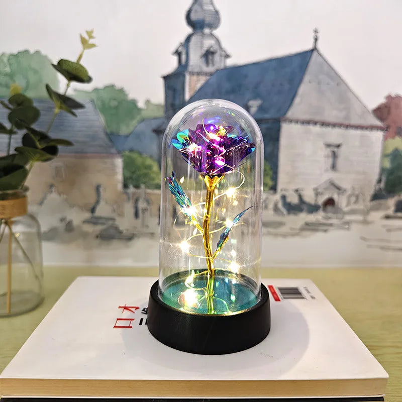 Une rose de verre éternelle avec une lumière LED est exposée sur un livre, avec un fond de peinture d'église et de paysage.