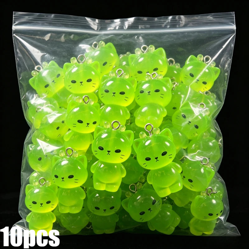 A bag of 10 glow-in-the-dark resin charms shaped like cats and ducks in various shades of lime green.