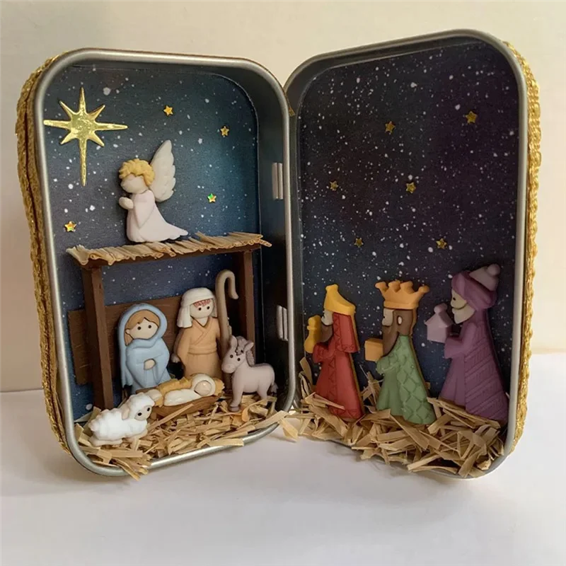 A tin box containing a nativity scene decoration featuring hand-painted figures, stars, and a starry background.