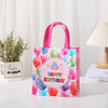 Pink and green festive non-woven gift tote bags with holiday prints displayed on a white surface.