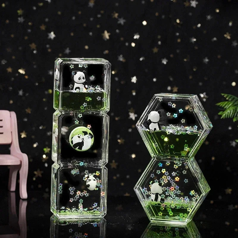A clear glass hourglass filled with green liquid and featuring a panda design, displayed on a dark surface.