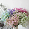 A bouquet of artificial gypsophila flowers in shades of pink, purple, and white.