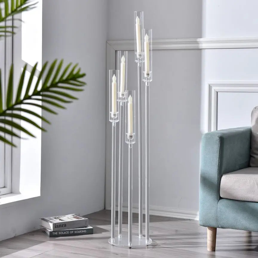 Un chandelier en acrylique transparent avec cinq bougies chauffe-plat dans un intérieur moderne.