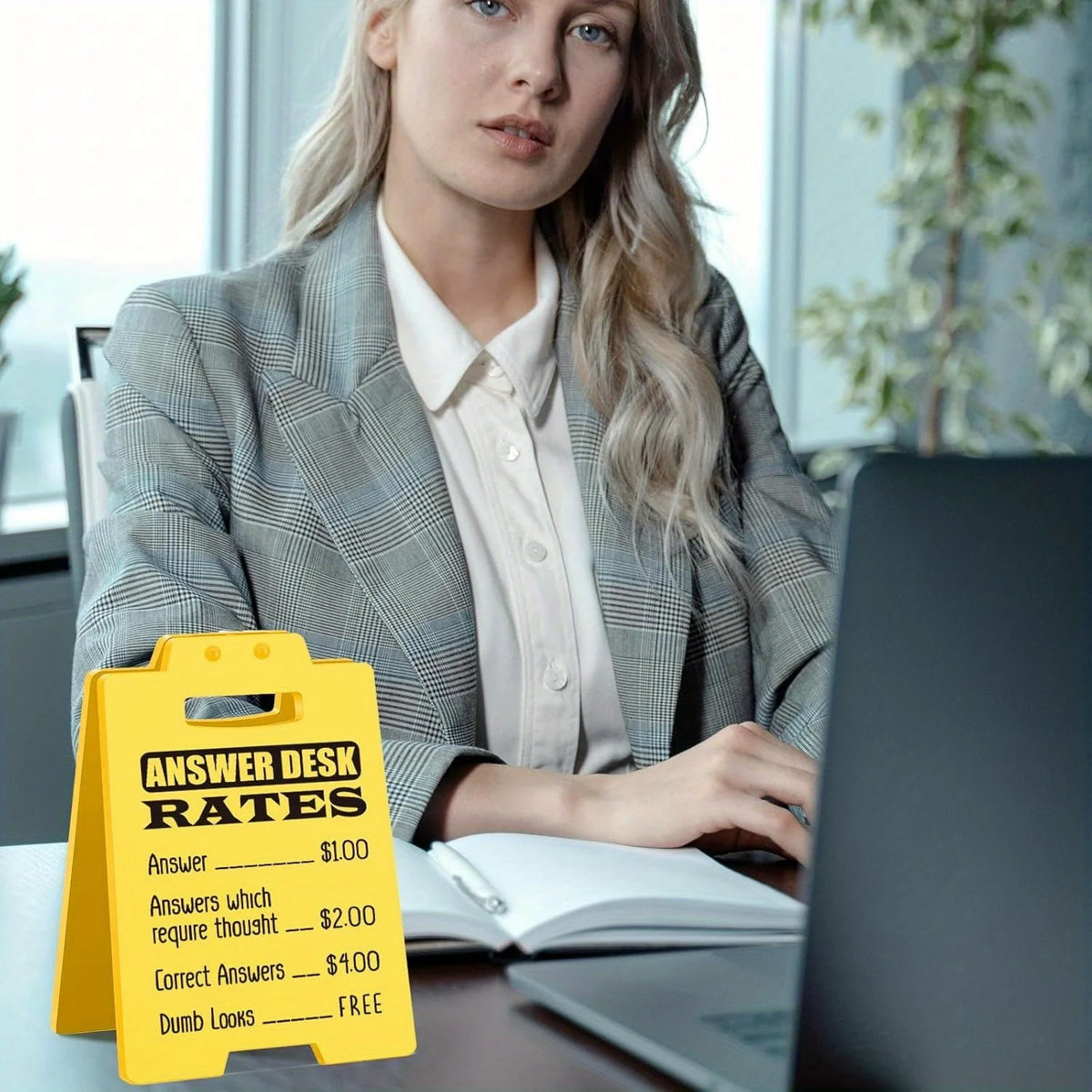 A yellow desk sign listing answer desk rates for $1.00, $2.00, and free answers, placed on a desk.