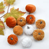 A set of ten velvet pumpkin decorations in various shades of orange and white, accompanied by autumn leaves.