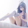 A figurine of an anime girl with light blue hair and clothing sitting in a relaxed pose.