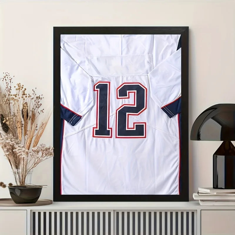 A framed white and blue sports jersey with the number 12 displayed on a wall.