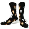 Pair of black novelty crew socks featuring repeating prints of skulls and people's faces.