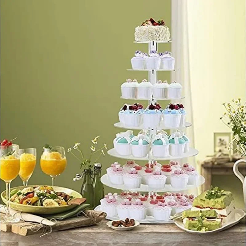 A three-tier clear acrylic cupcake stand displaying various frosted cupcakes and desserts.