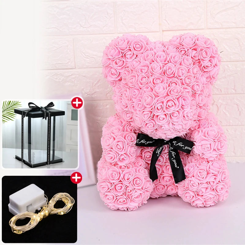 Un ours rose et moelleux en forme de rose avec un ruban noir et une décoration lumineuse LED.