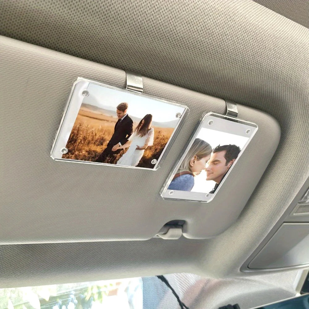 A car sunshade photo frame with a magnetic visor clip holder displaying two people.