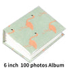 A green photo album with an orange flamingo design featuring a pink-orange bird silhouette.