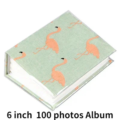 A green photo album with an orange flamingo design featuring a pink-orange bird silhouette.