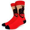 A pair of red crew socks featuring a black cat print with gold lettering on the leg.