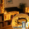 A close-up of flexible willow branch LED lights illuminating a shelf with books and decorative items.