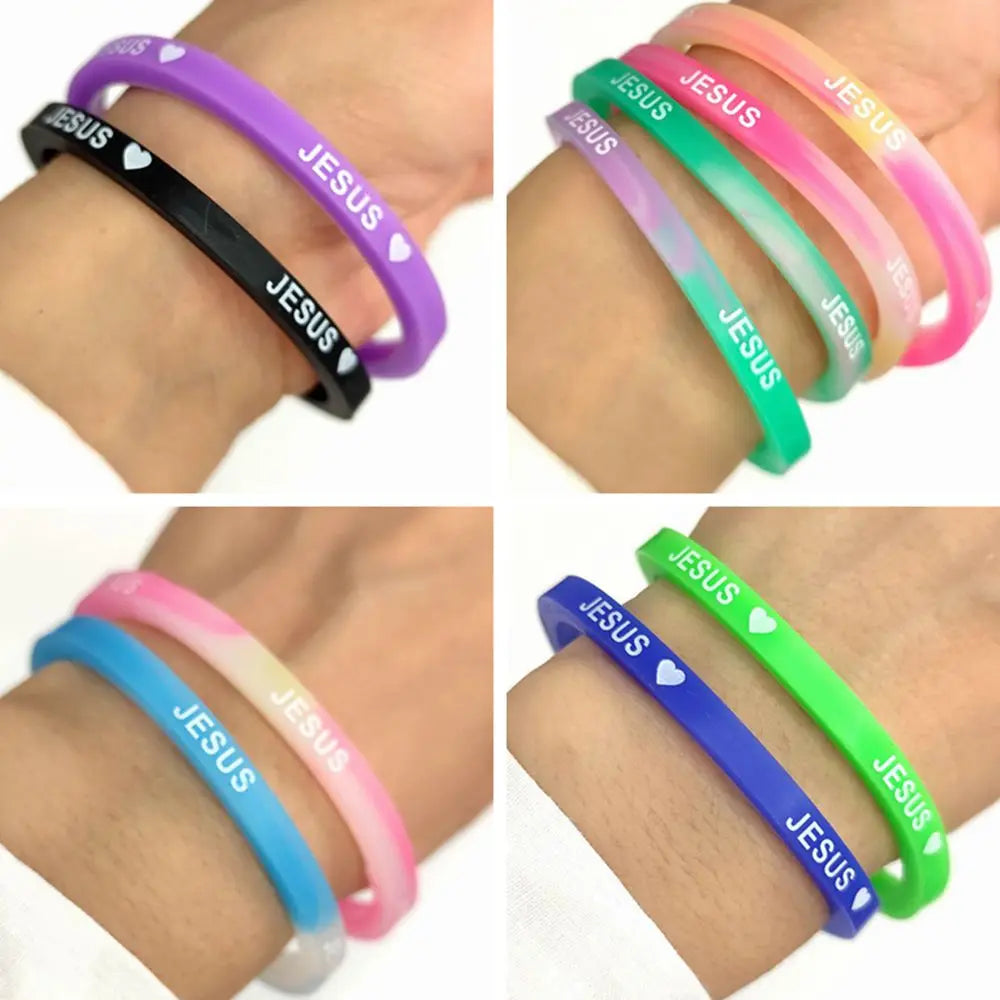 A collection of silicone bracelets featuring the word JESUS with a heart design in various colors like purple, pink, green, a