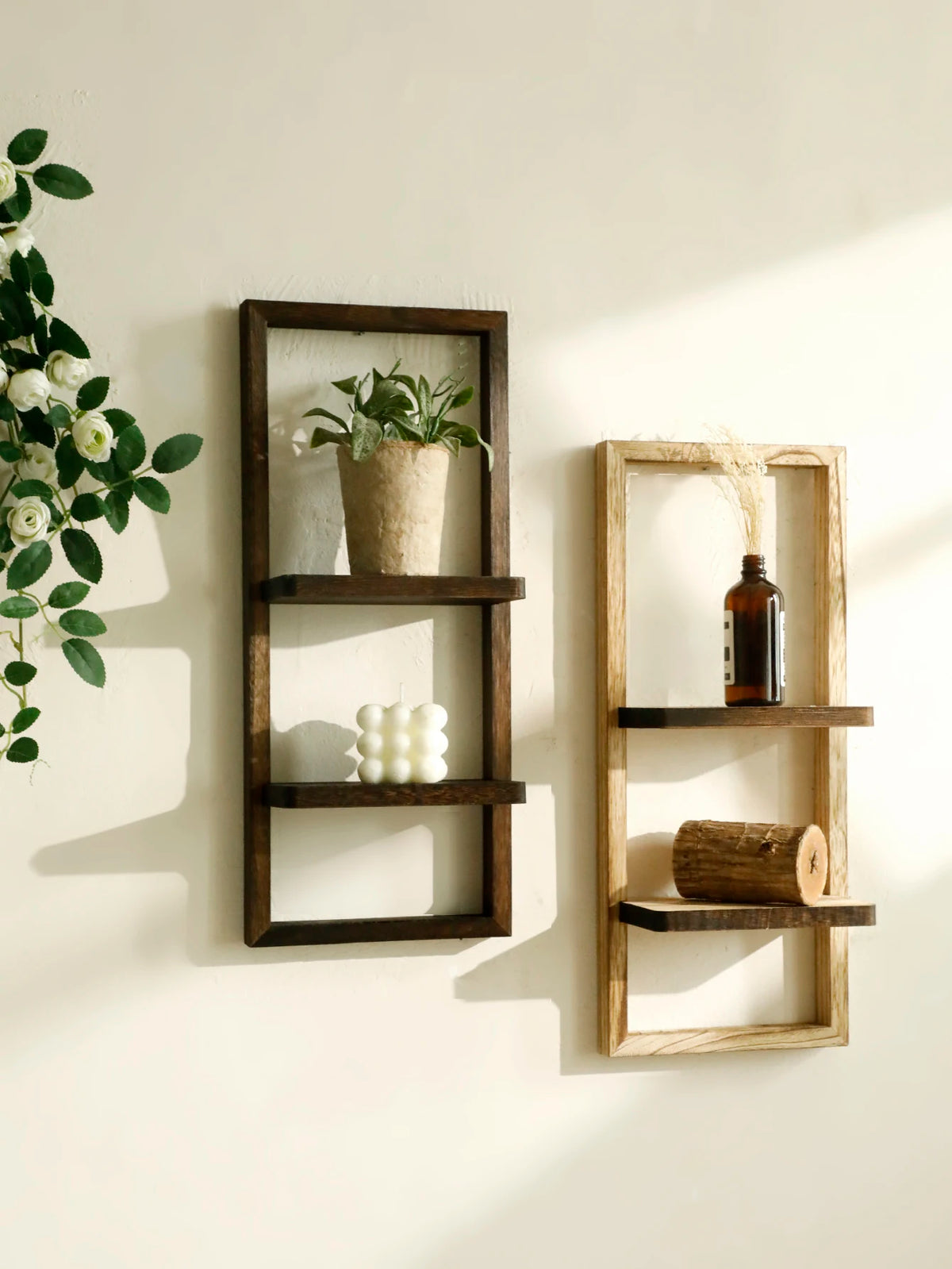 A rustic wooden floating shelf with two tiers displaying a potted plant and a glass bottle.