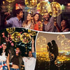 A group of people celebrating outdoors with glowing LED light-up balloons and string lights.