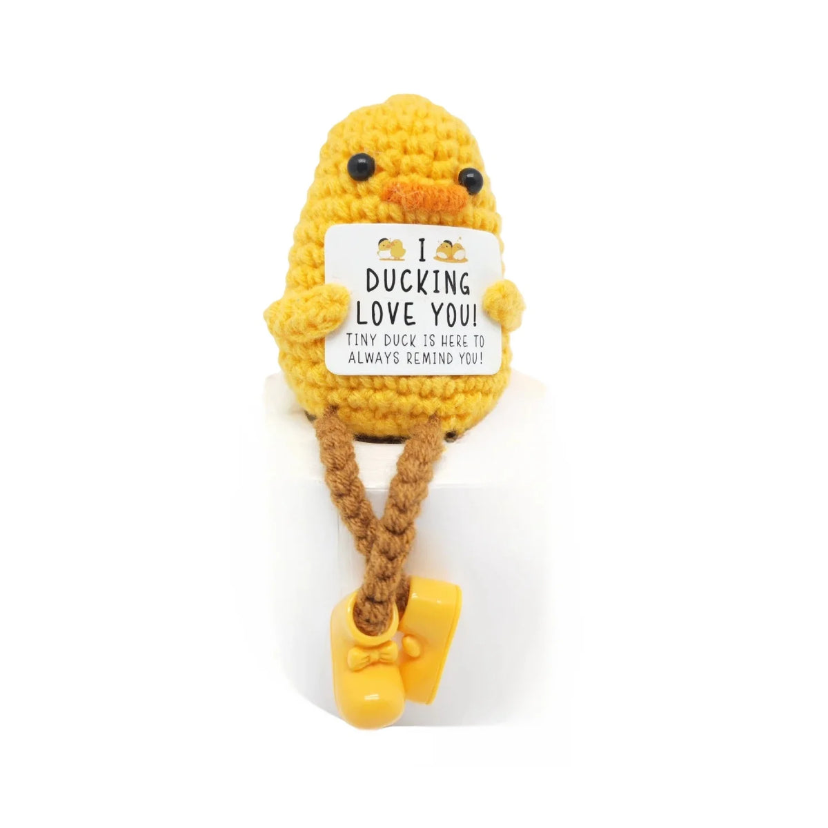A yellow knitted plush doll shaped like a duck with a tag that reads I DUCKING LOVE YOU