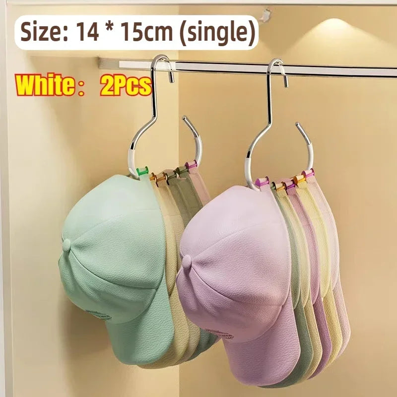 Two white round multi-purpose closet hooks displaying various colored hats and bags.