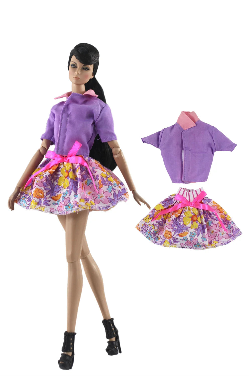 A handmade doll dress gown featuring purple and pink floral patterns with ruffled collars and bows.