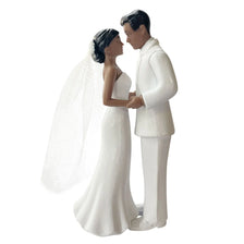 A white wedding cake topper featuring an elegant bride and groom figurine.