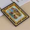 A framed icon depicting Jesus, Mary, and Joseph with an angel, set in a gold-edged black frame.