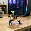 A female rifleman desktop figurine in tactical gear is displayed on a wooden surface.