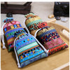 A set of ten vintage cotton drawstring gift pouches in various colorful patterns and textures resting on a wooden surface.