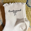 White socks with black embroidery that read Bridesmaid