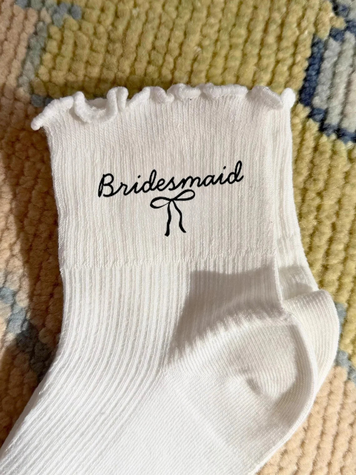 White socks with black embroidery that read Bridesmaid