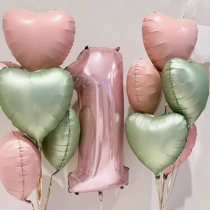 A cluster of pink and green heart-shaped foil balloons tied together for a celebration