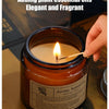 A hand-poured soy aromatherapy candle in a glass jar with a lit wick, adding plant essential oils for an elegant and fragrant