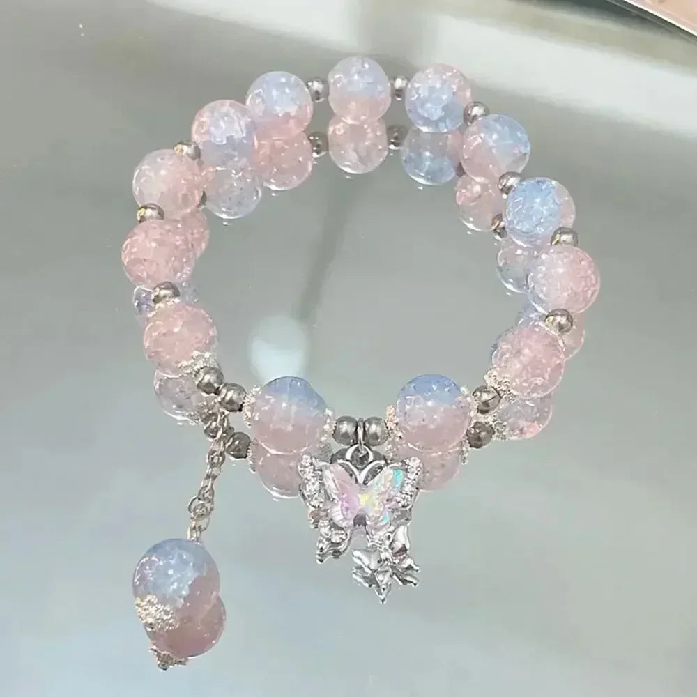 A bracelet made of pink and blue natural stone beads with a silver charm shaped like a butterfly.