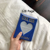 A blue photo album titled Cool Kids with a heart design resting on white bedding.