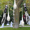 A display of Halloween decorations featuring skull-faced spider web silhouettes and light-up egg shapes hanging from tree bra