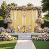 A luxurious gold sequin backdrop curtain decorated with pink and white floral arrangements for an event or photoshoot.