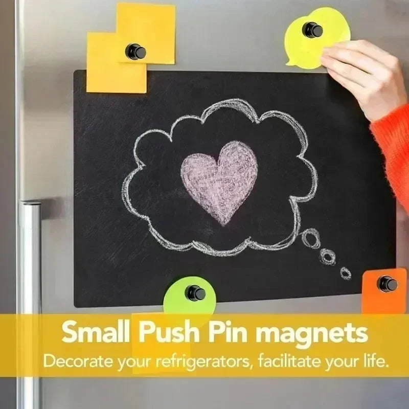Kleine Pushpin-Magneten dekorieren eine Tafel mit einem Herzen und Sprechblasen