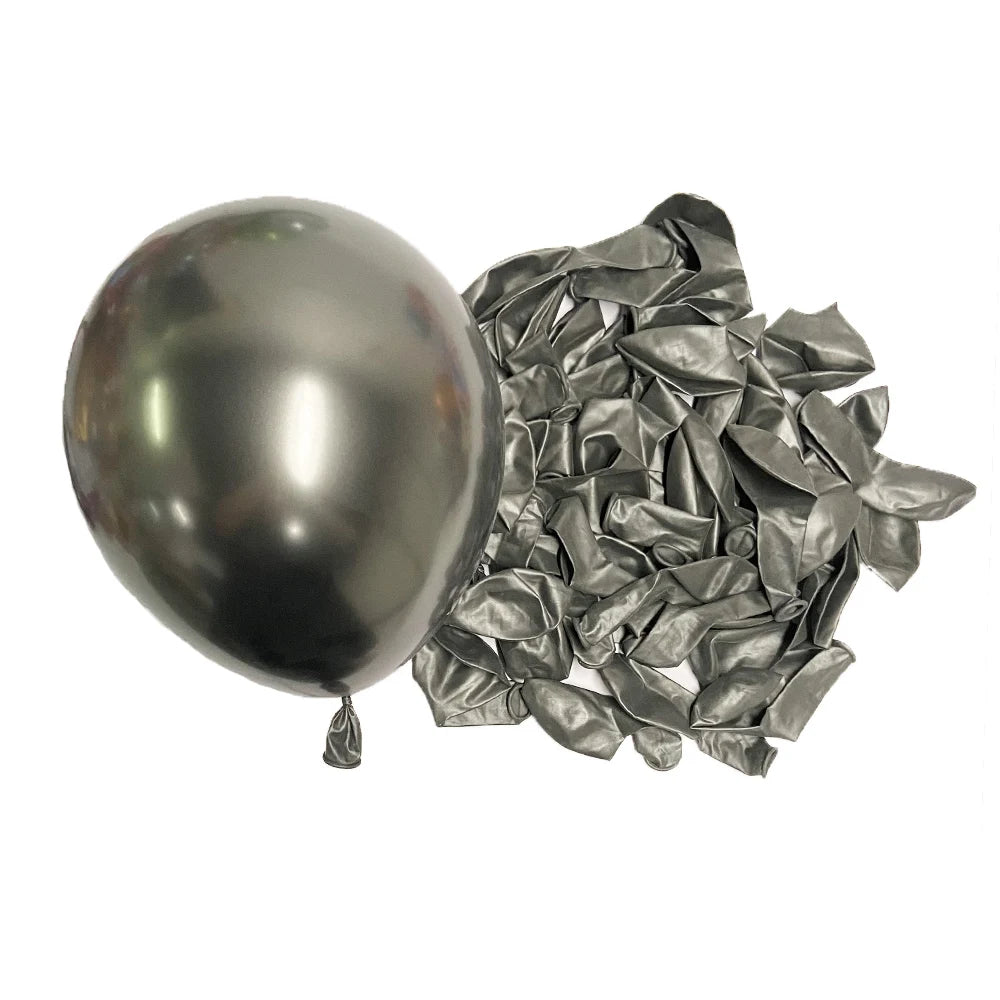 A single silver metallic latex balloon next to a pile of crumpled silver foil balloons.