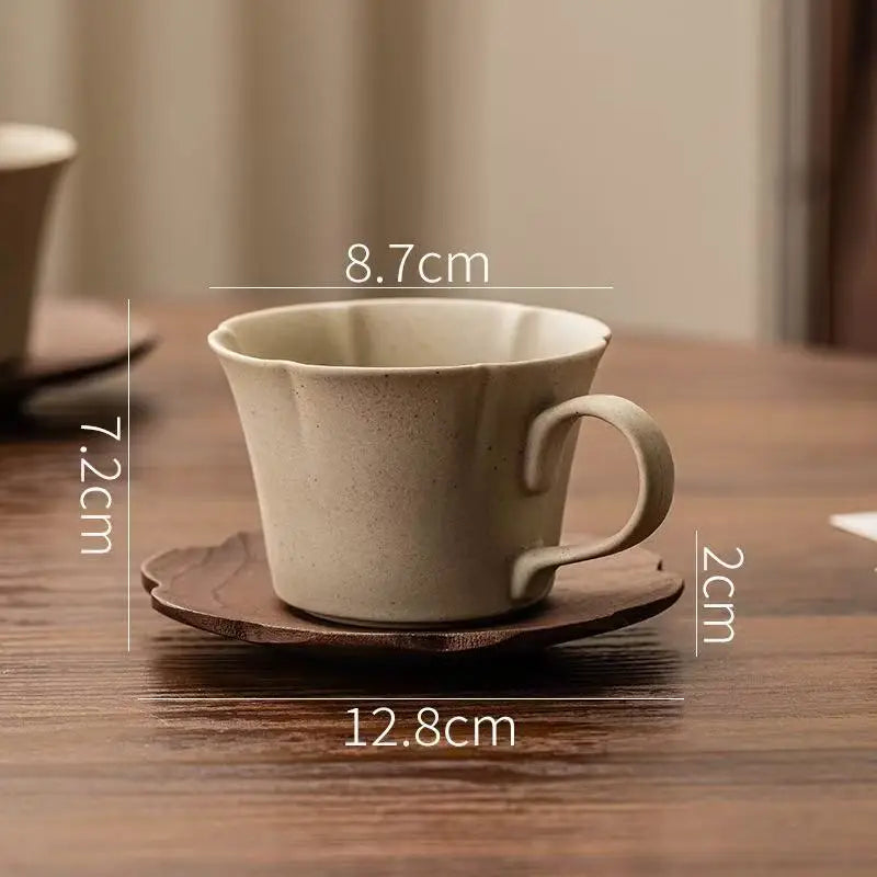 A beige ceramic coffee cup and saucer set displayed on a wooden surface.