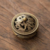 A vintage brass alloy incense burner holder featuring a detailed dragon design on a dark surface.