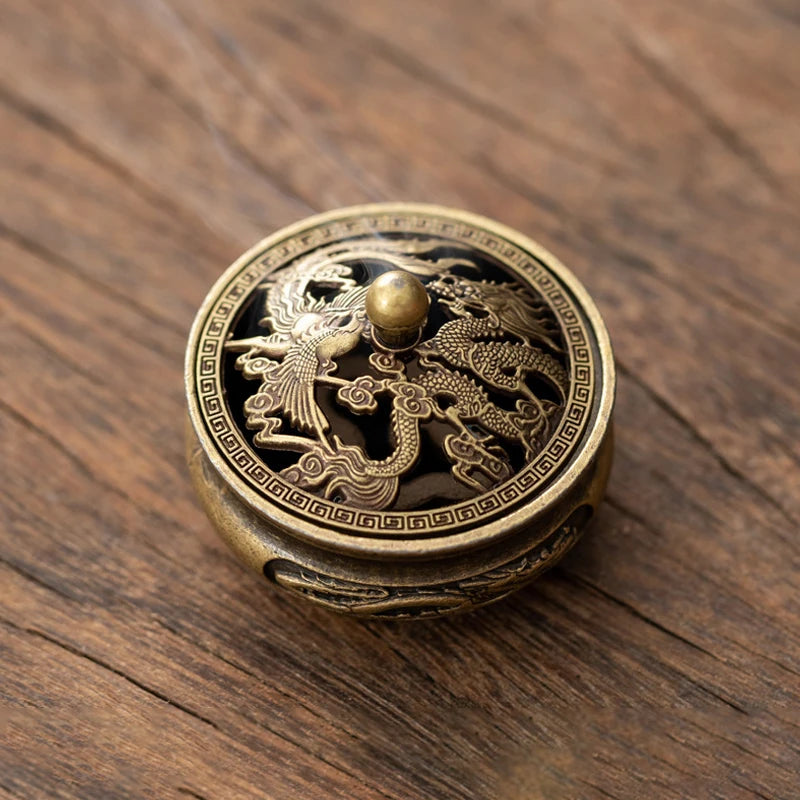 A vintage brass alloy incense burner holder featuring a detailed dragon design on a dark surface.