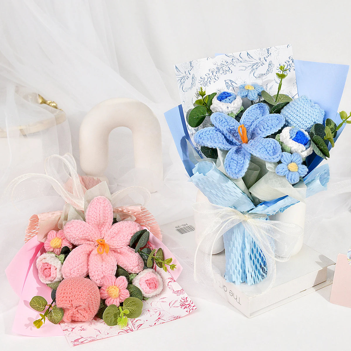 A bouquet of handmade crochet blue and white tulips wrapped in light blue paper and tissue paper.